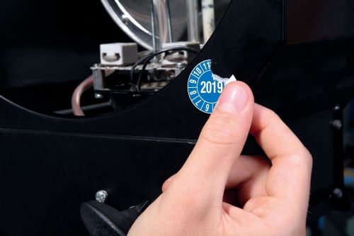 Materialbild zeigt den Versuch die Papier Plakette vom Objekt abzulösen diese zerreißt gleich