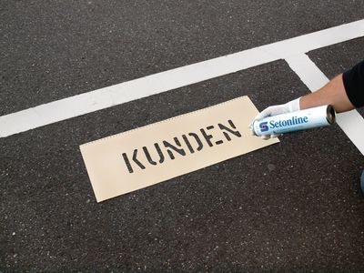 Bodenmarkierung mit Text-Schablone und Markierspray