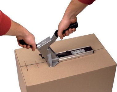 Paket wird mit einem Kartonverschluss-Hefter verschlossen