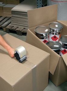 Paket wird mit einem Paketbandabroller verschlossen